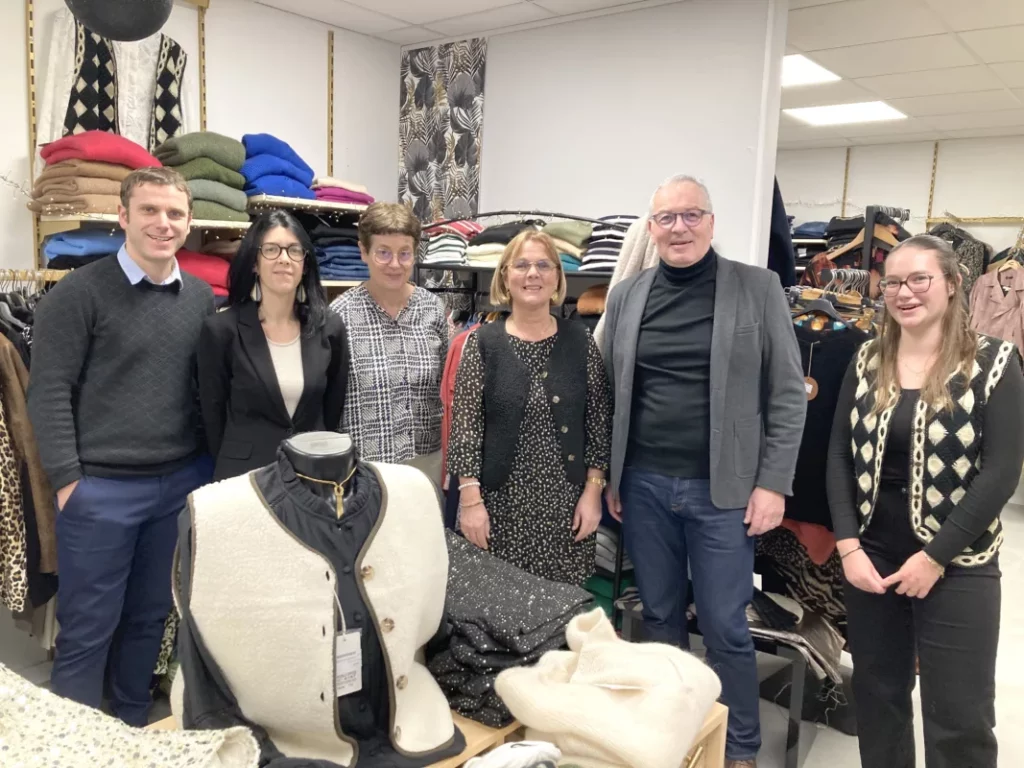 Différents représentants de la Région et de Loudéac Communauté étaient présents dans la boutique Addict Chic aux côtés de sa propriétaire et de sa stagiaire. Ils posent au devant d'étagères de vêtements.