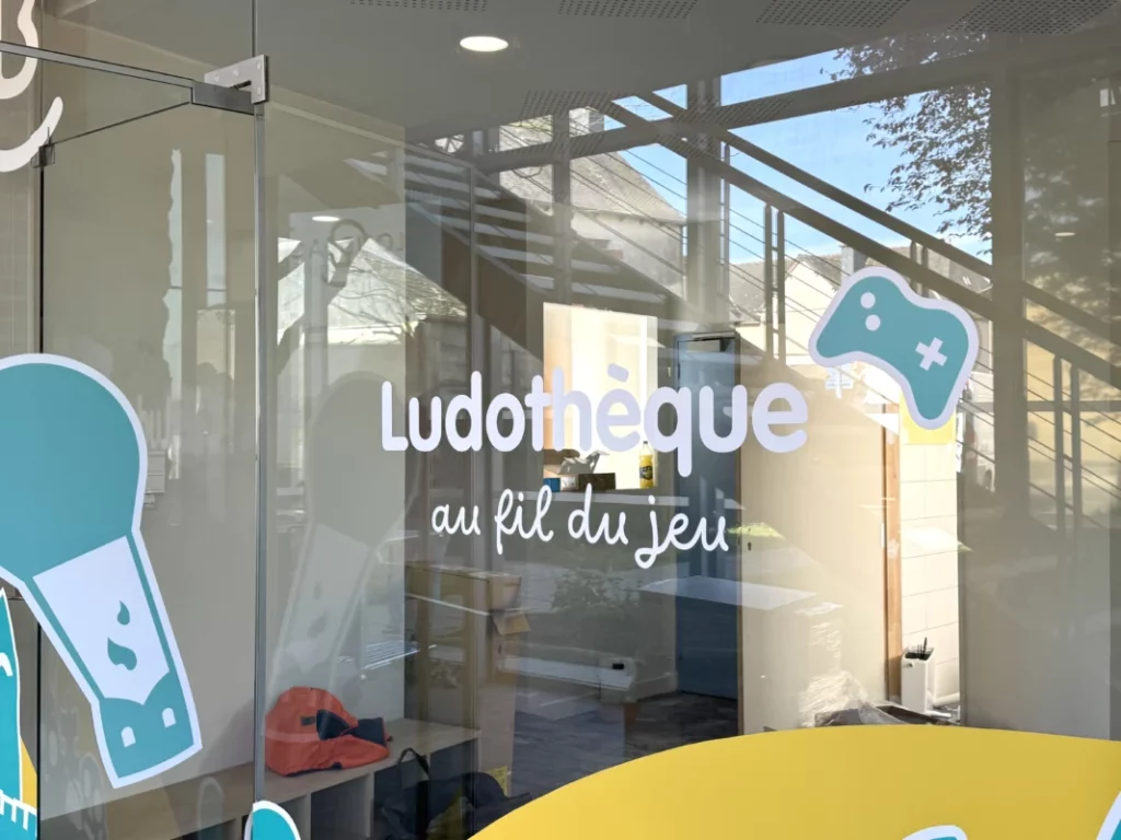 L'inscription de la ludothèque collée sur une vitre.