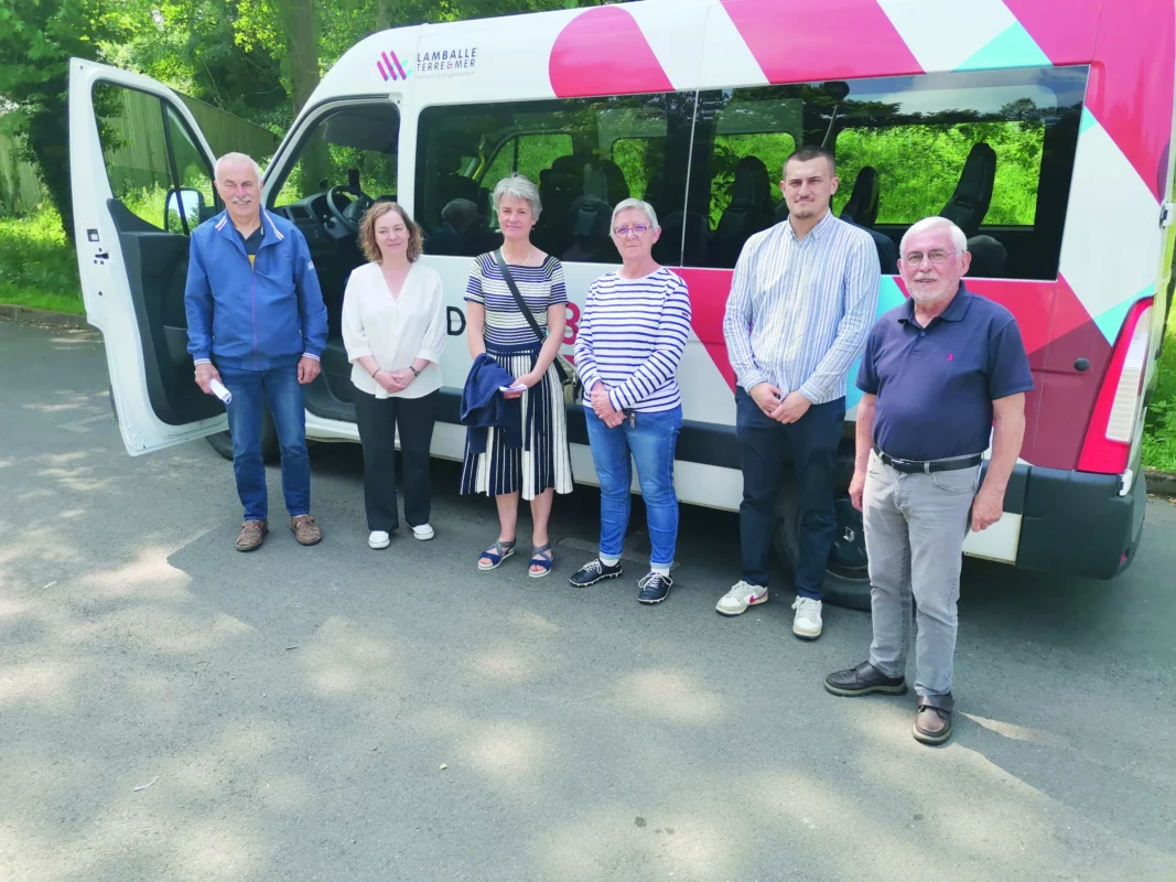Des élus et du personnel devant un bus.