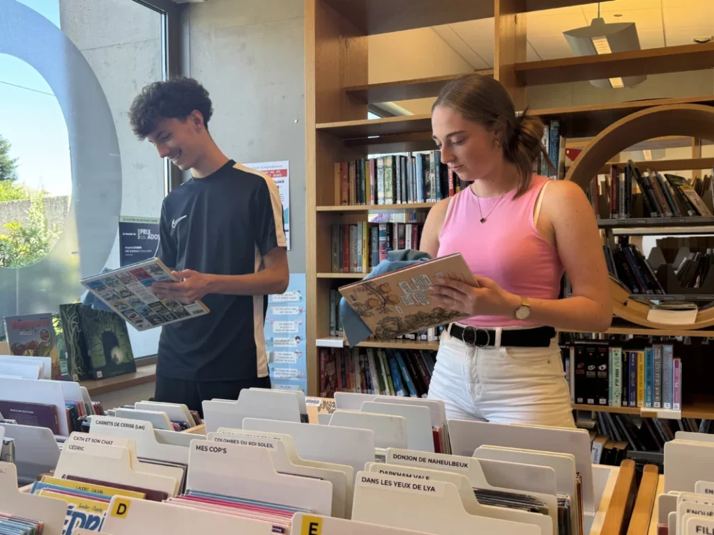 Deux adolescents nettoient des livres.