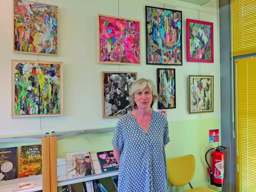 L'exposition de collage est au derrière d'un membre du personnel de la médiathèque.