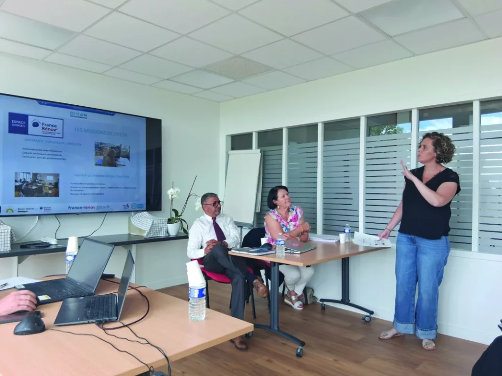Pauline est à droite debout et présente cette nouvelle aide à deux personnes assises.