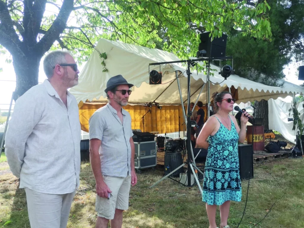 Les organisateurs du concours parlent et sont devant une tonnelle.