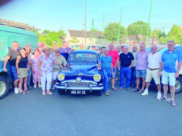 Les membres de l'association sont autour d'une vieille voiture.