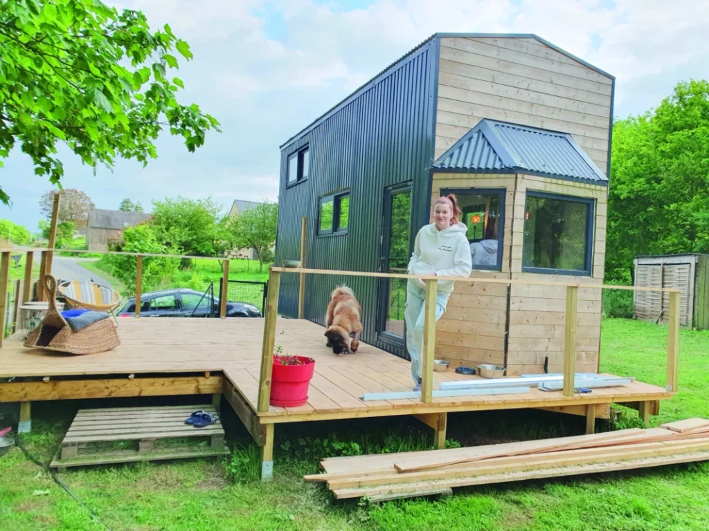 Marion se trouve sur la terrasse de sa tiny-house.