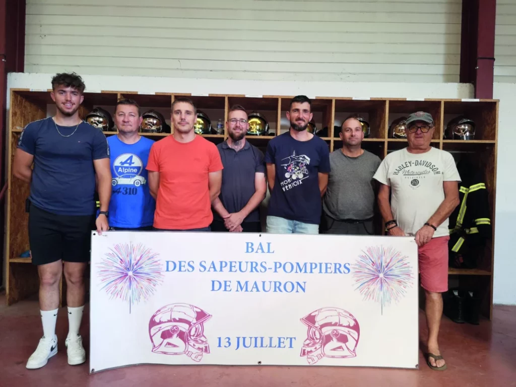 Les membres de l'amicale des sapeurs-pompiers tiennent une banderole annonçant les festivités.