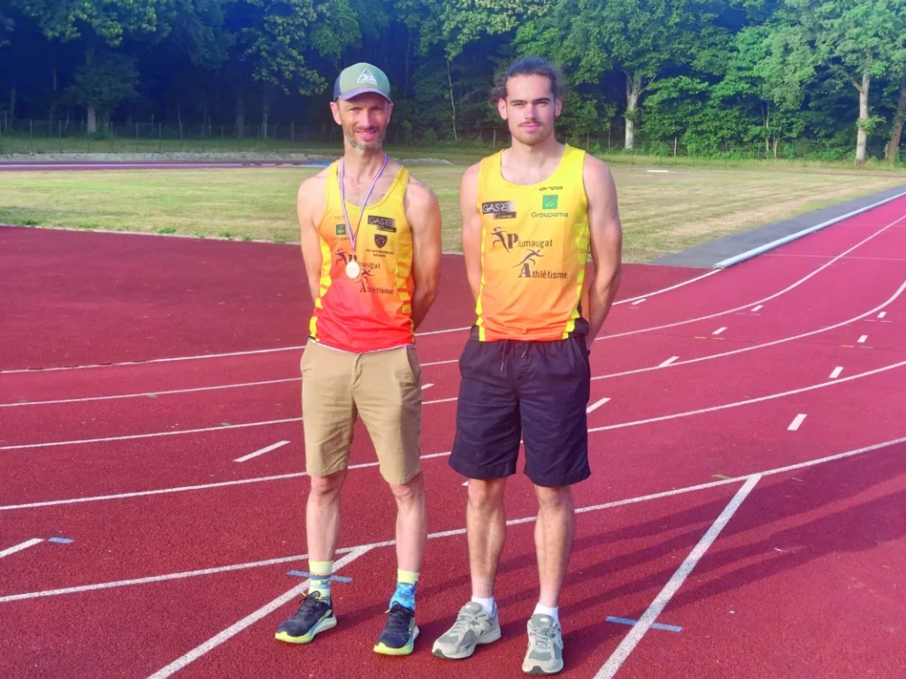 Les deux champions sont debout sur la piste d'athlétisme.