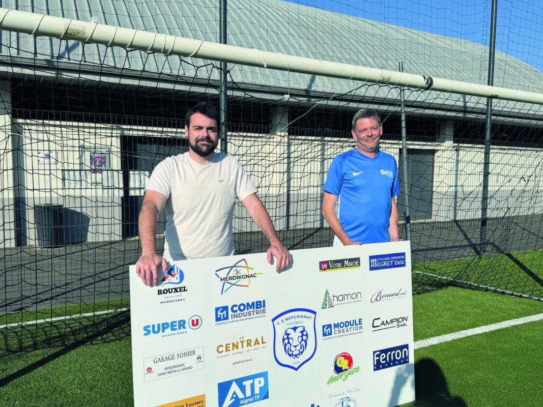 Le président et le coach sont dans un but en train de tenir le panneau avec tous les sponsors.