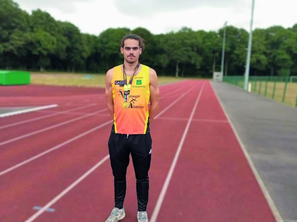 Le champion du monde pose sur la piste et porte sa médaille.