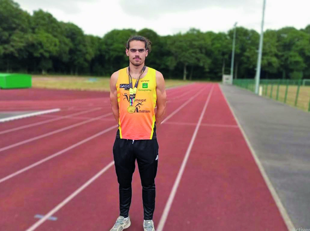 Le champion du monde pose sur la piste et porte sa médaille.