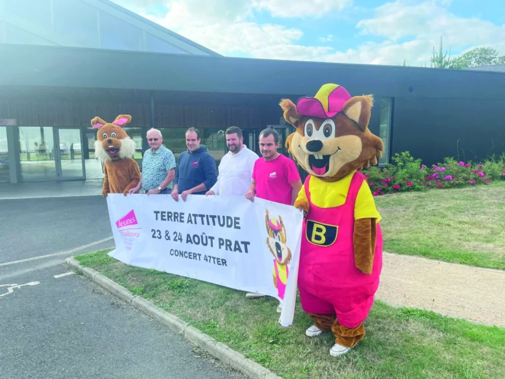 Des membres de l'association tiennent une banderole avec deux mascottes.