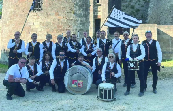 Des musiciens sont en tenue bretonne avec des instruments et des drapeaux de la région.