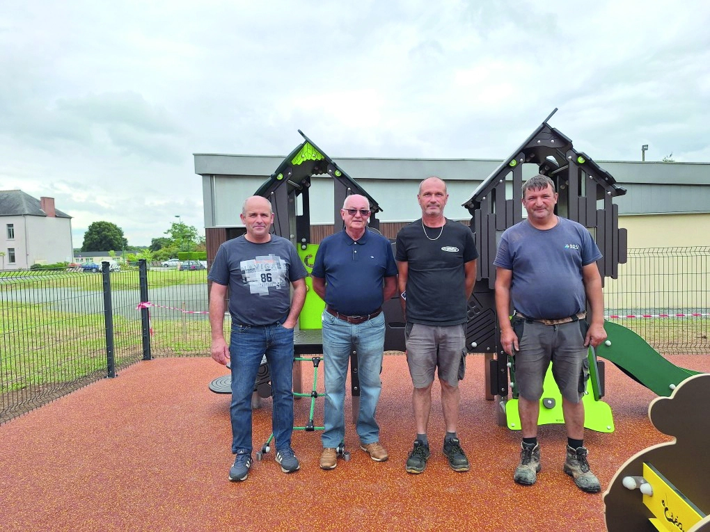 Le personnel municipal a terminé l'aire de jeu. Ils sont devant les jeux.