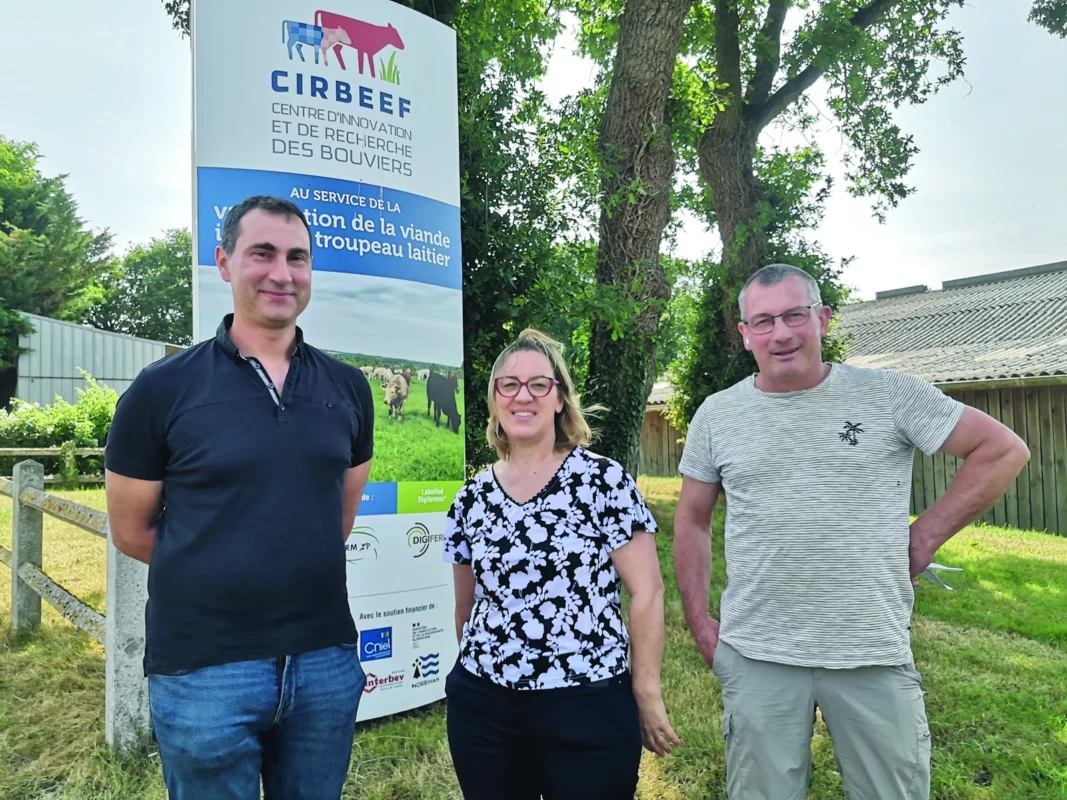Trois personnes sont devant le panneau de cette ferme expérimentale.