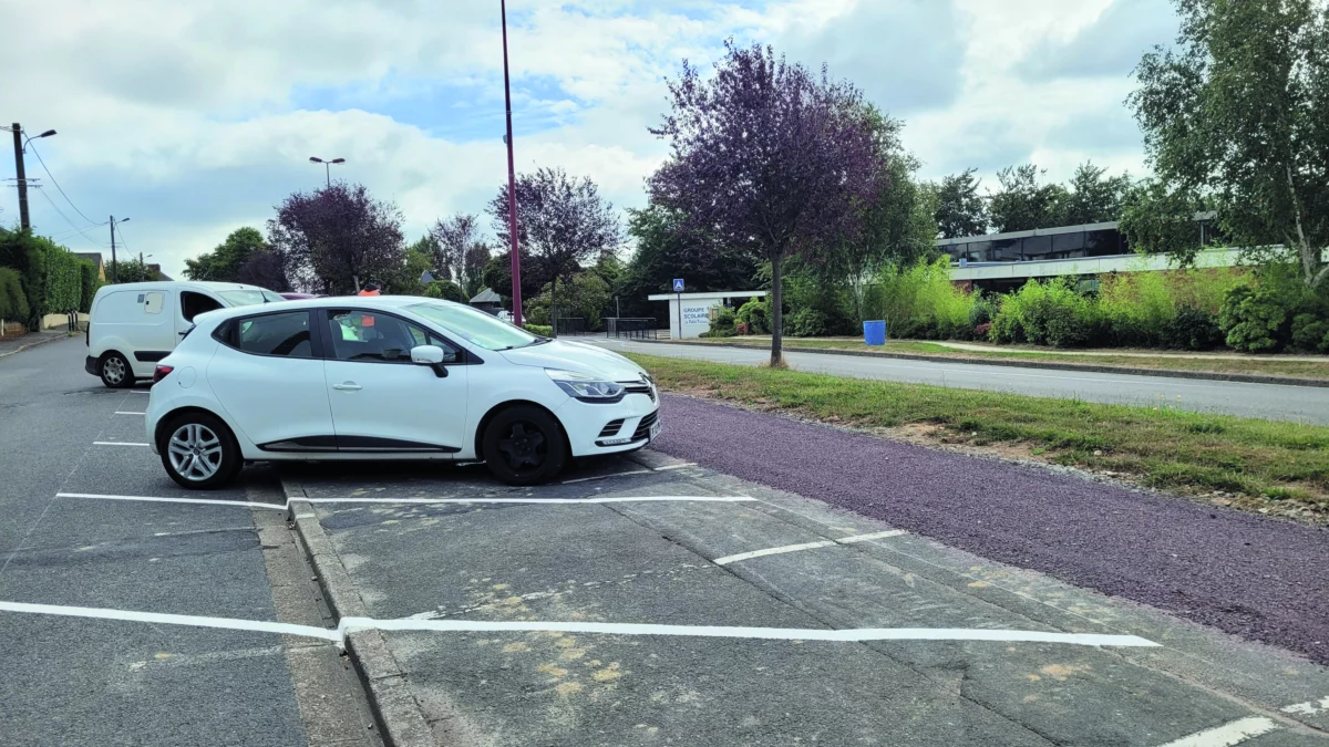 Une voiture blanche est garée sur un nouveau parking.