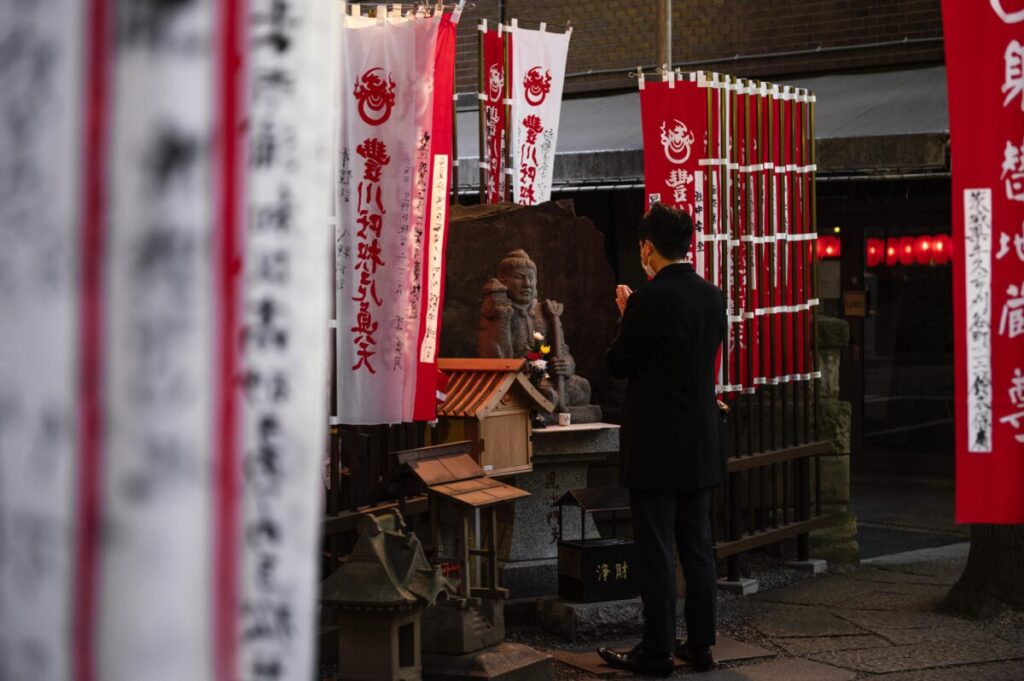 Banderoles japonaises sur différents plans de la photo et une statue.