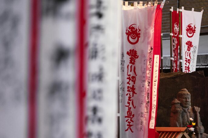 Banderoles japonaises sur différents plans de la photo et une statue.